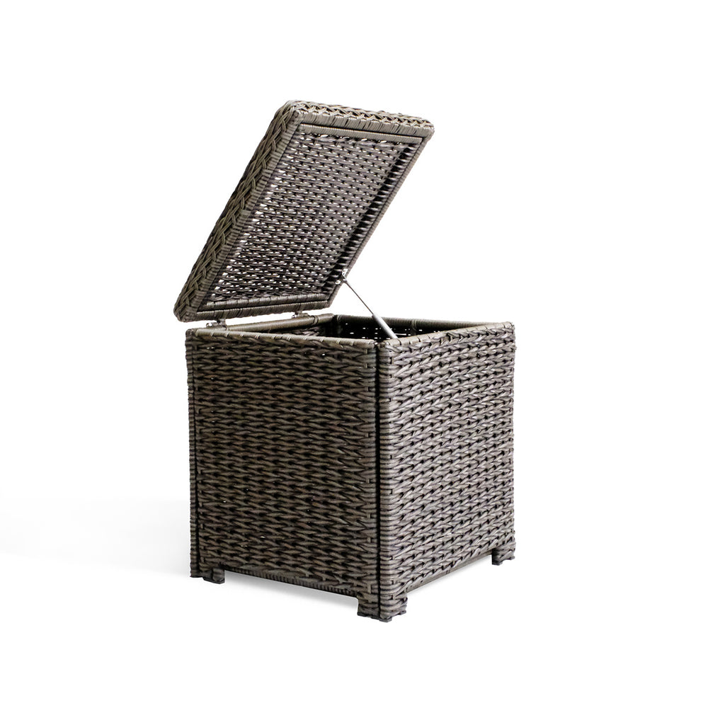 Side view of the Laguna Point end table with open lid, showcasing the resilient wicker frame and tempered glass top.