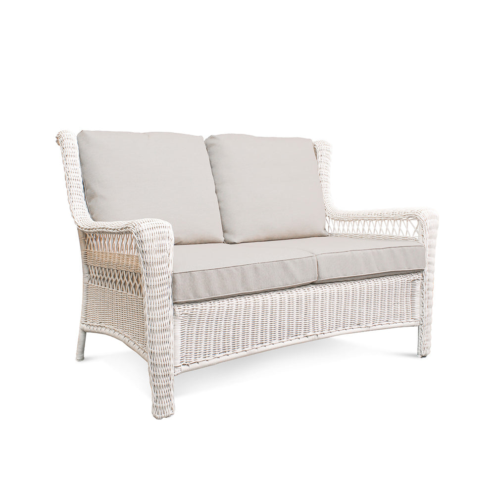 Corner view of Park Meadows Wicker Outdoor Loveseat showcasing plush cushions and elegant diamond weave details, outdoor setting in Oakville, ON.