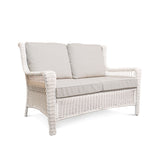 Corner view of Park Meadows Wicker Outdoor Loveseat showcasing plush cushions and elegant diamond weave details, outdoor setting in Oakville, ON.