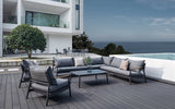 Landscape view of Monti sectional set placed on an outdoor patio, with a stunning ocean view in the background.