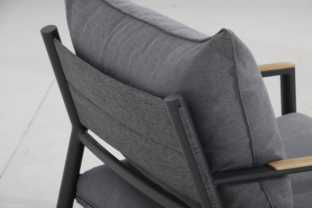 Close-up view from the back of the Monti sectional set, showcasing the cushions and teak wood armrests.